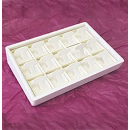 A white tray with 1 6 pieces of white chocolate.