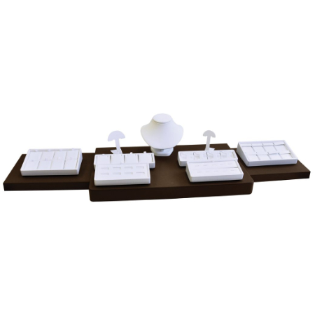 A set of four white jewelry trays on top of a wooden stand.